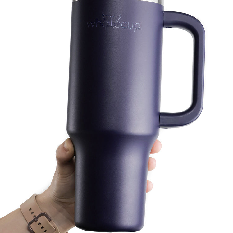 Hand holding matte black Whalecup tumbler against white background